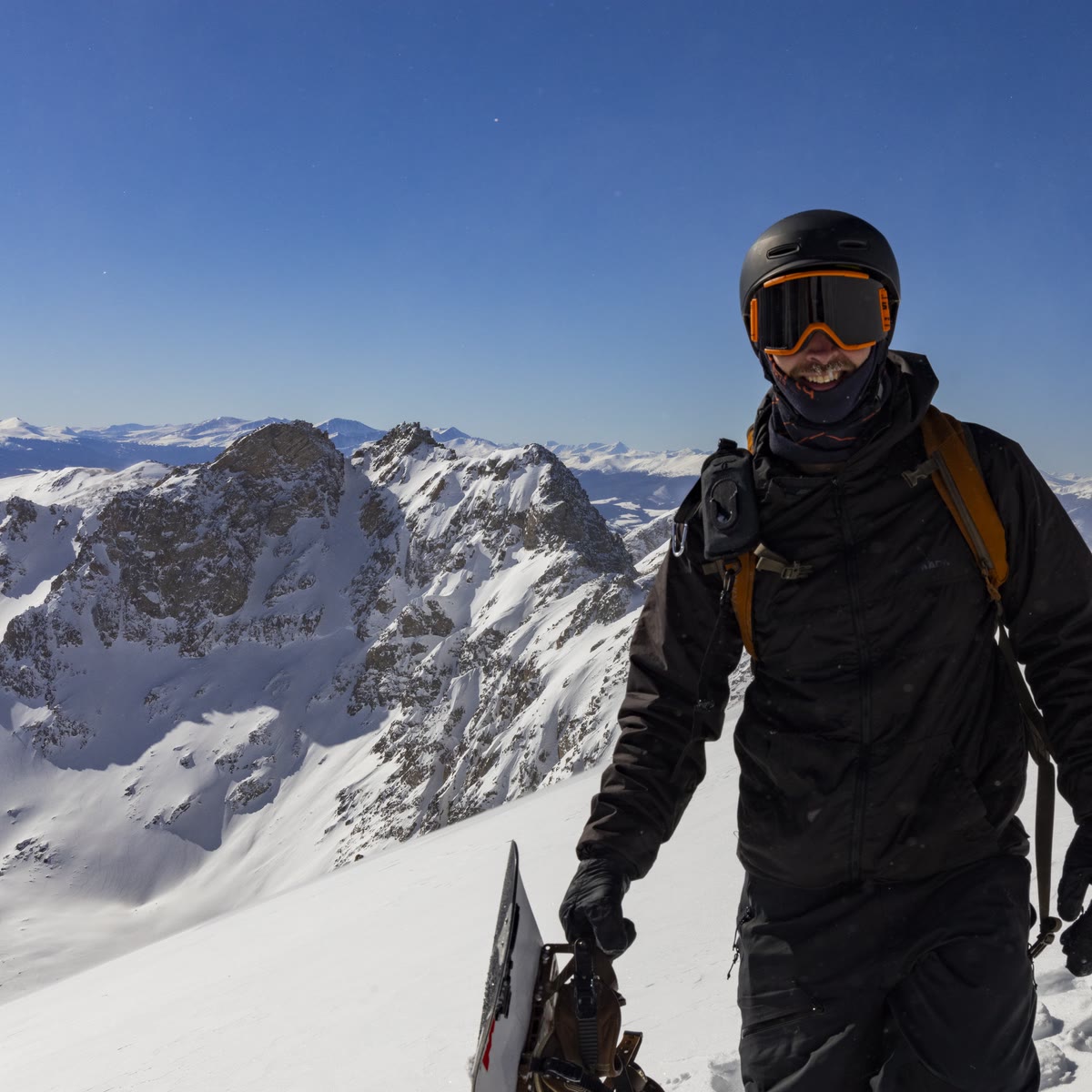 Grayson Geiger on a summit with his snowboard