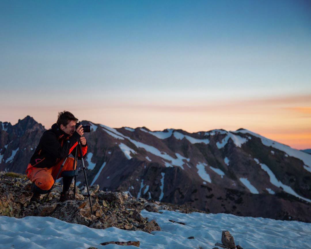 Grayson Geiger shooting at alpenglow on a Colorado ridgeline